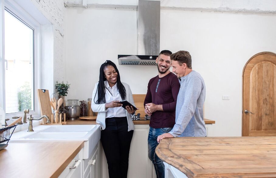 An estate agent showing a couple around a kitchen