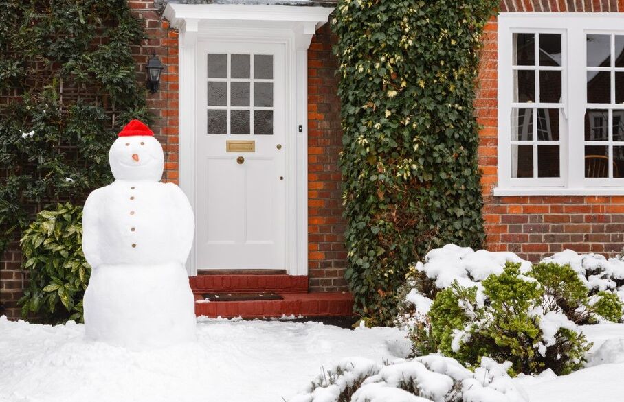 A snowman outside a home