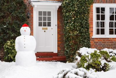 A snowman outside a home