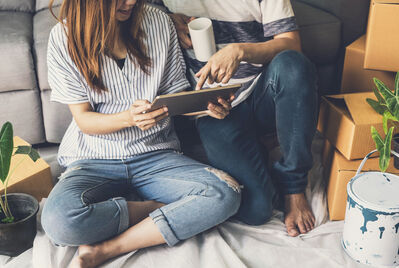 Two people sat on the floor in front a tablet