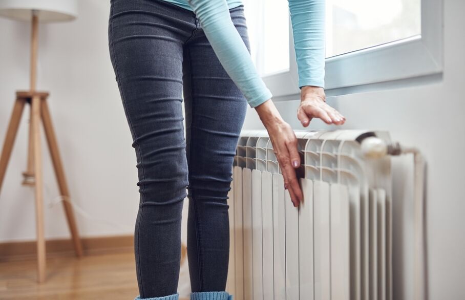 A person's hands on a radiator