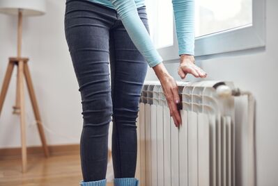 A person's hands on a radiator