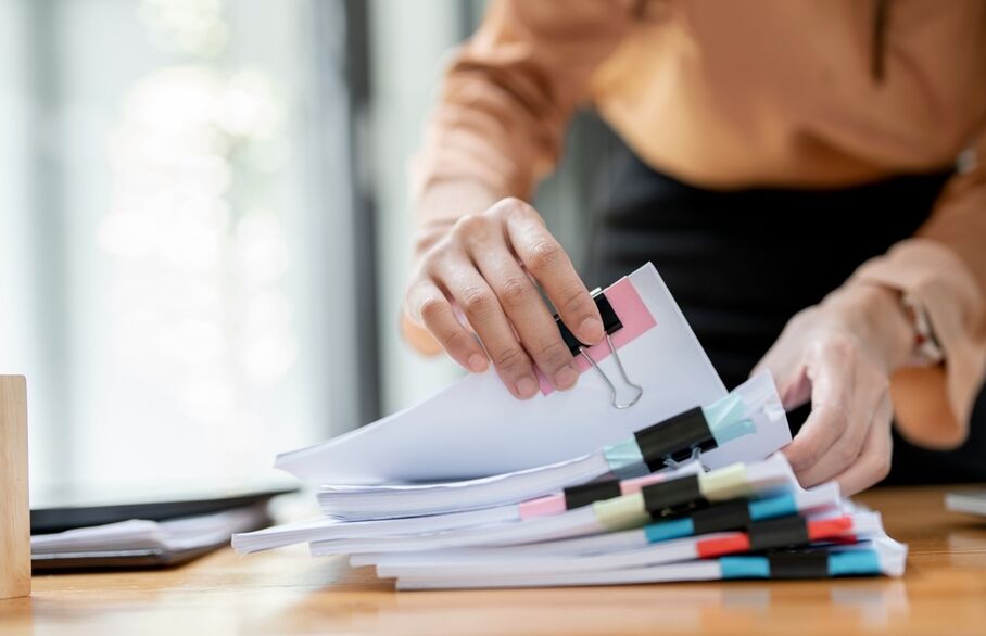 Someone looking through a stack of paper