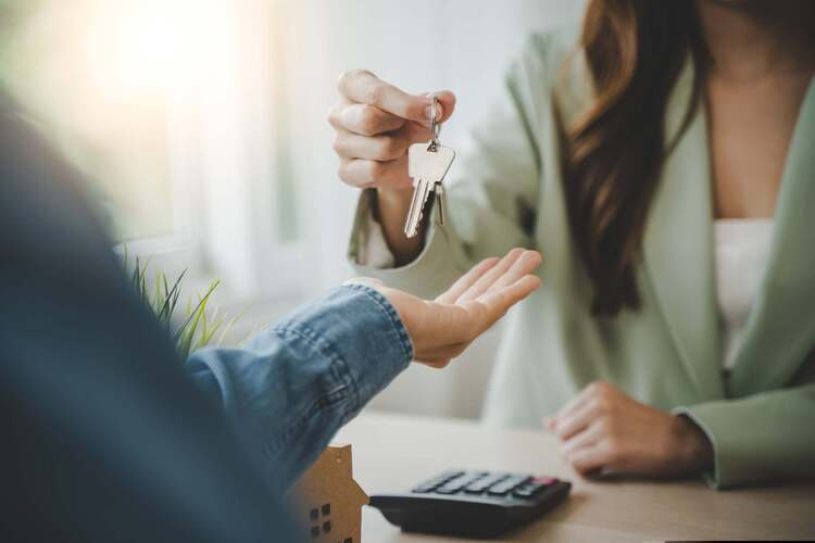 A person handing over a housekey 