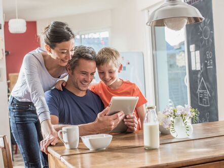 A family looking happily at a laptop