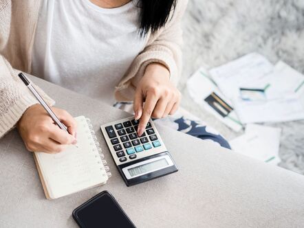 A woman sitting in front of a calculator