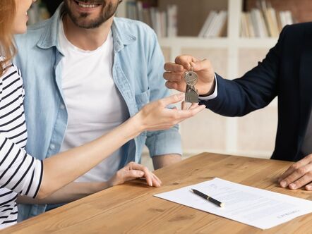 happy couple receiving keys from rental property