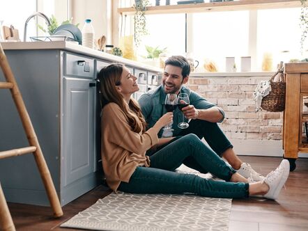 A couple drinking together in the kitchen